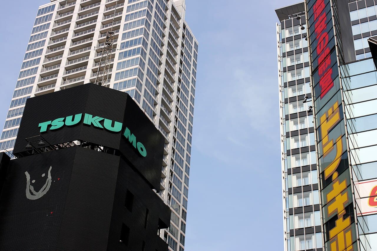 Street view of the Don Quijote discount store building in Akihabara, Tokyo, with the Tsukumo eX electronics store beside it and Akihabara UDX tower in the background